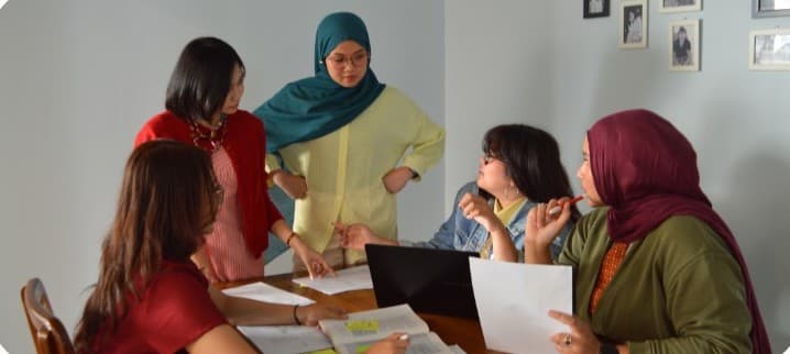 BOI Research team discussing research materials around a table